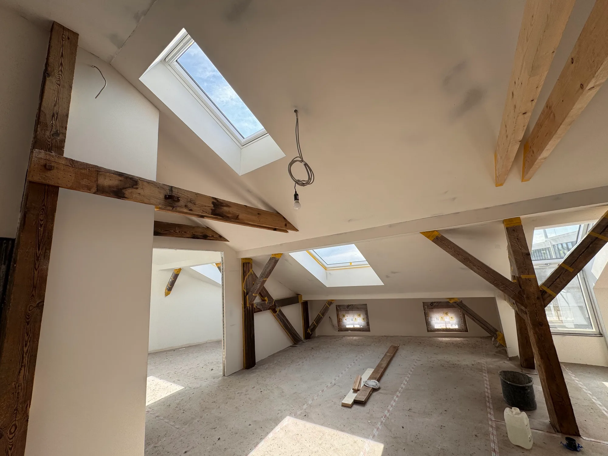 Großzügig ausgebautes Dachgeschoss in Berlin-Mitte mit zwei Dachfenstern und sichtbaren Holzbalken