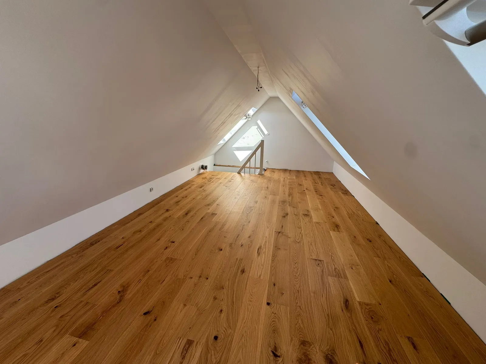 Dachausbau mit verlegtem Eichen-Dielenboden – Dachgeschoss mit Dachschrägen, Dachfenstern und sauberer Ausführung. Dachausbau Referenz – verlegter Eichen-Dielenboden im ausgebauten Dachgeschoss in Berlin & Brandenburg